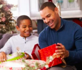A father and son enjoying opening a Christmas present